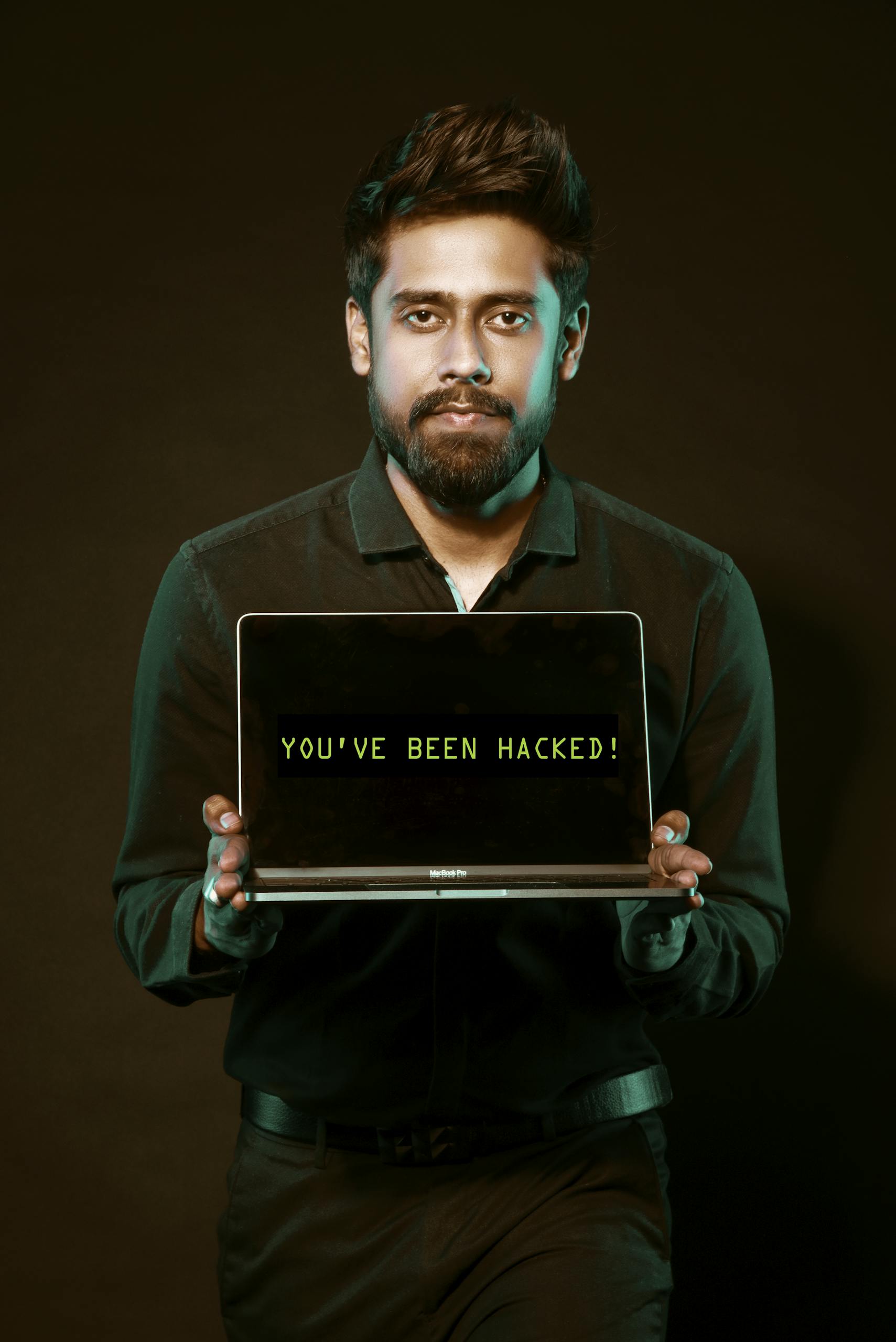 A man showing a laptop with a 'You've been hacked' message, symbolizing cyber security threats.